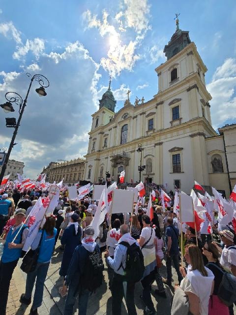 Marsz Solidarności — uczestnicy z flagami Polski w centrum Warszawy